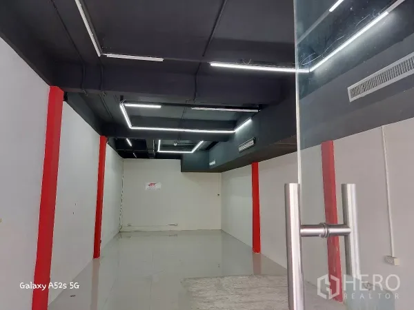 Retail Space for rent in Khlong Toei, Bangkok - Entrance view of the retail unit showing modern lighting, exposed black ceiling and clean white walls.