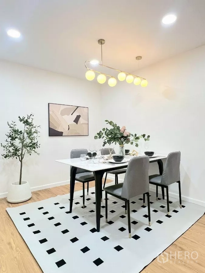 Detached House for rent in Huai Khwang, Bangkok - Spacious dining area on a patterned rug with potted plant and modern lighting.