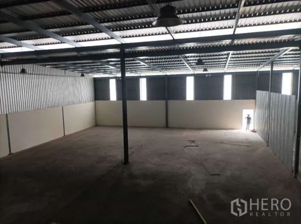 Factory for rent in Ban Phaeo, Samut Sakhon - Wide warehouse space with strip windows and side exit door bringing in natural light.