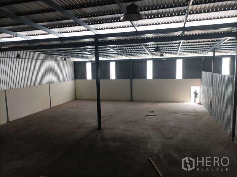 Factory for rent in Ban Phaeo, Samut Sakhon - Wide warehouse space with strip windows and side exit door bringing in natural light.