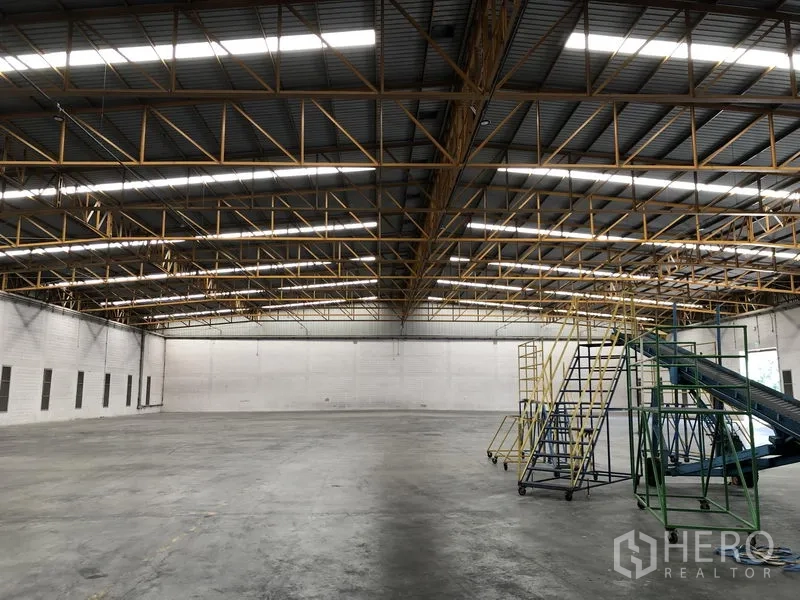 Warehouse for rent in Phra Nakhon Si Ayutthaya - Bright warehouse hall with steel roof trusses and movable maintenance stairs.