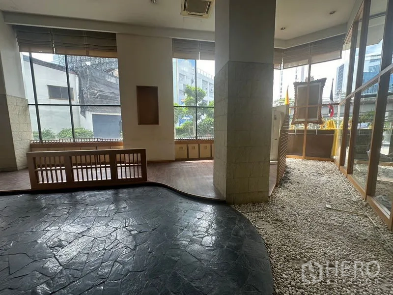 Retail Space for rent in Bang Rak, Bangkok - Corner retail area with tall windows, stone and pebble flooring, and city views.