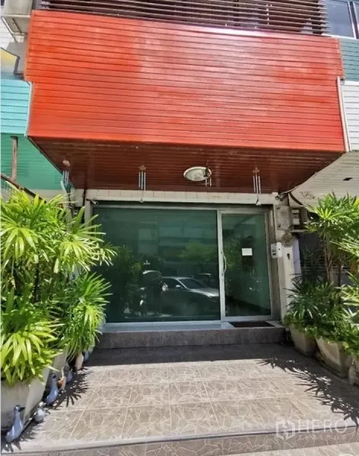 Office Space for rent in Huai Khwang, Bangkok - Facade of low‑rise commercial building with sliding glass door and planter-lined steps.