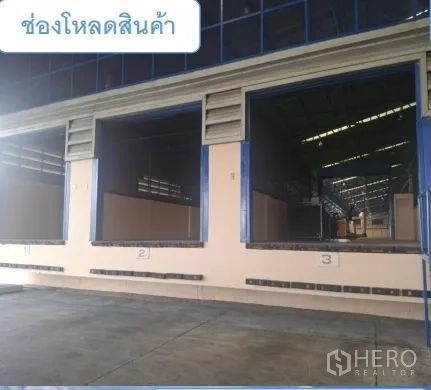 Warehouse for rent in Mueang Pathum Thani, Pathum Thani - Series of truck loading bays with raised docks and blue shutters.