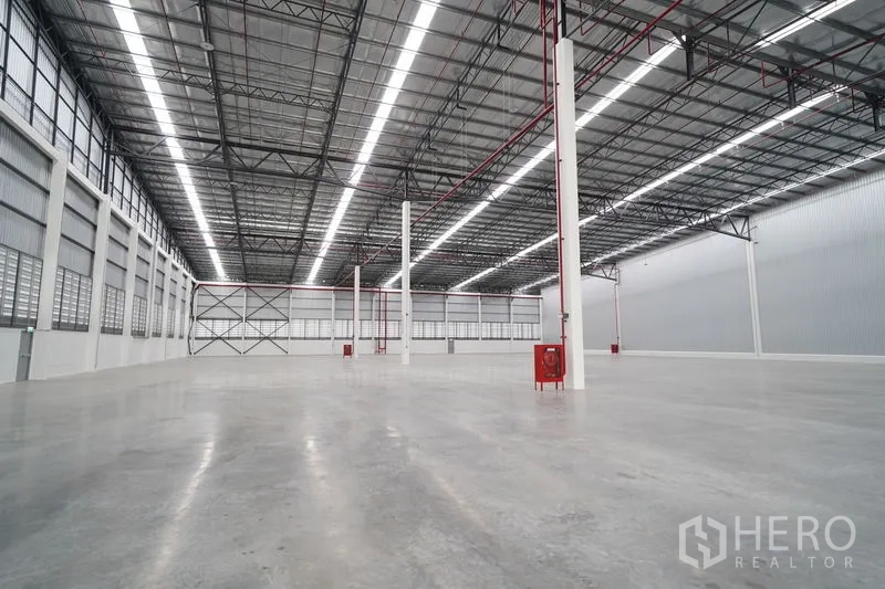 货栈 出租在Khlong Luang, Pathum Thani - 宽阔仓储空间，立柱与消防管线，侧墙百叶窗及端墙交叉支撑