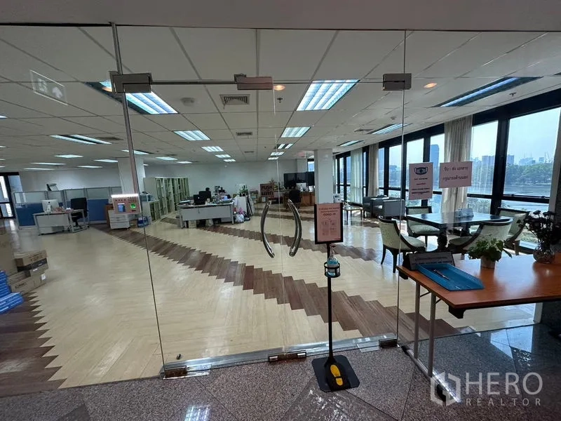 Office Space for rent in Khlong Toei, Bangkok - Glass double-door entrance leading to a bright office with herringbone flooring and panoramic park and city views.