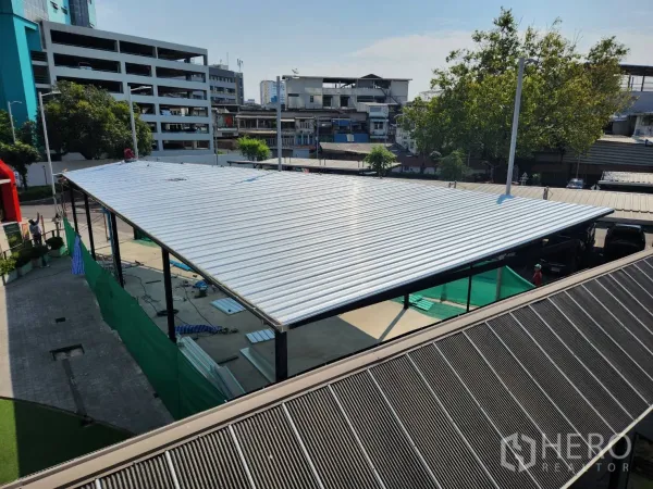 Retail Space for rent in Khlong Toei, Bangkok - Aerial view of metal-roofed retail pavilion within a mixed-use complex, with trees and city buildings around.