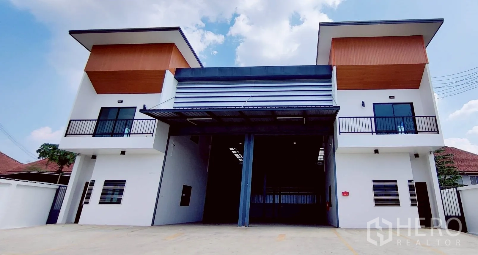 Warehouse for rent in Lam Luk Ka, Pathum Thani - Front view of the building showing dual office blocks and a high entry canopy.