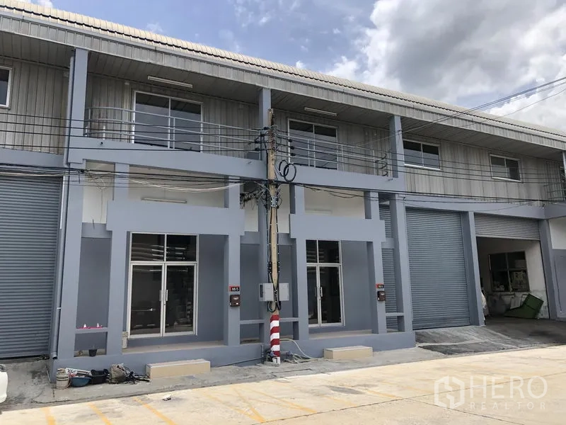 Factory for rent in Pak Kret, Nonthaburi - Row of adjoining factory units with upper balconies and large loading doors.