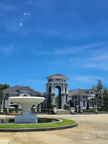 Detached House for rent in Thanyaburi, Pathum Thani - Grand gated community entrance with archway, fountain and landscaped roundabout