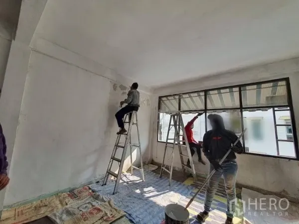 店屋 出租在Bangkok - 宽敞房间，长条窗户，地面摆放翻修工具与梯具