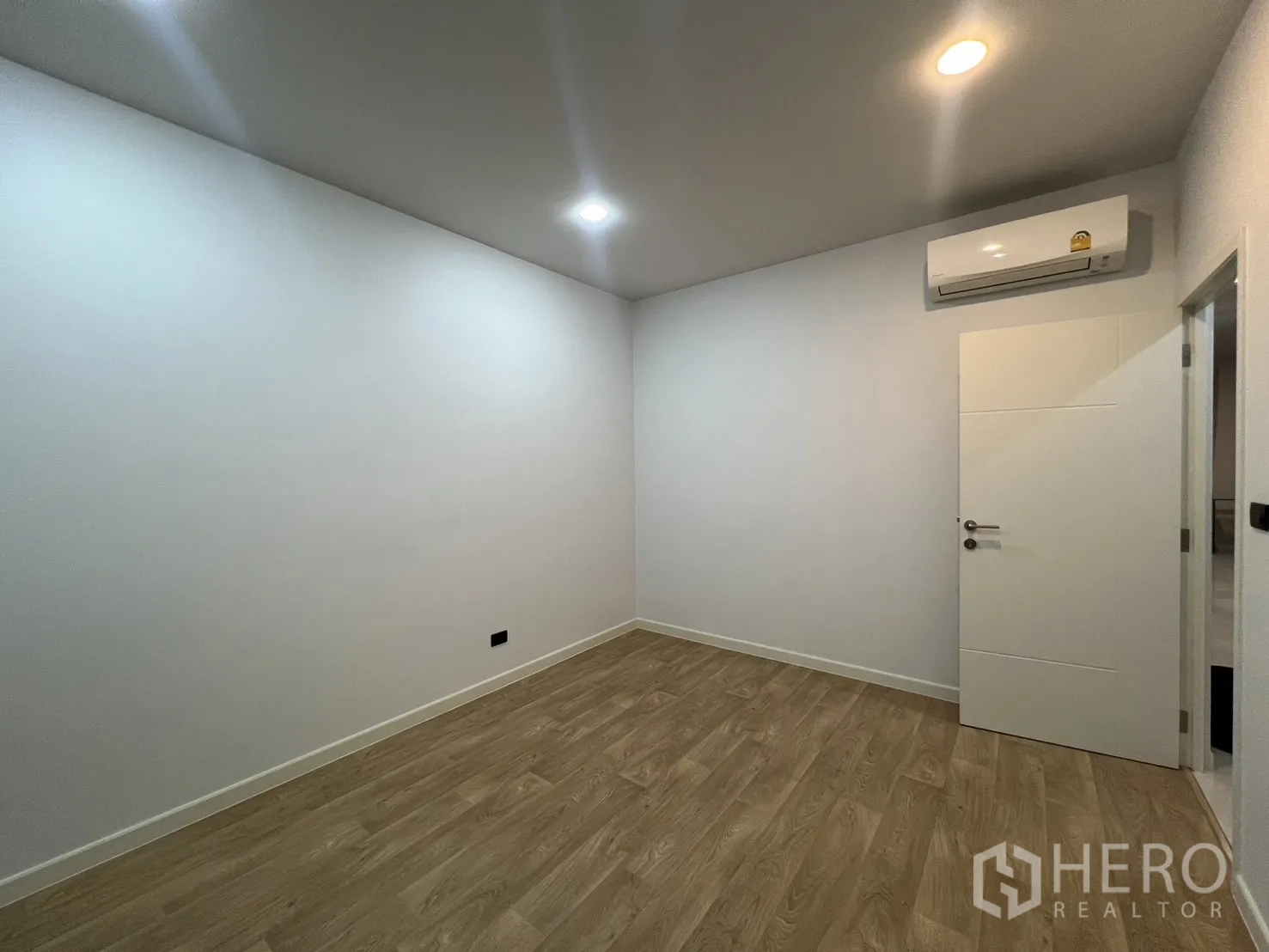 Detached House for rent or sale in Bang Kapi, Bangkok - Spare room with air conditioner, wood flooring and a white door