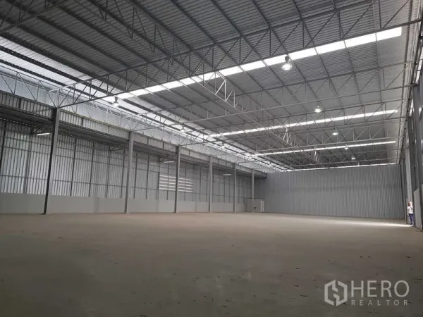 Warehouse for rent in Lat Krabang, Bangkok - Spacious high-ceiling warehouse interior with steel trusses, skylight panels and smooth concrete floor.