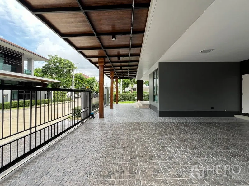 Detached House for rent in Bang Kapi, Bangkok - Large covered carport and patio with metal gate facing a quiet street.