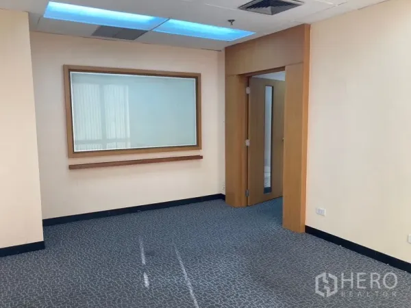 Office Space for rent - Private office room with built-in display panel, wooden door and acoustic ceiling lights.