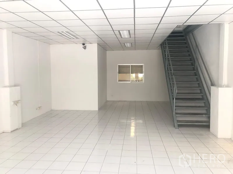 Factory for rent in Khlong Luang, Pathum Thani - Ground-floor office space with tiled floors and internal metal staircase.