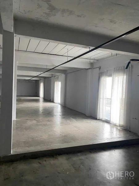 Retail Space for rent in Bang Na, Bangkok - Bright corner with floor-to-ceiling curtains and a step level change.
