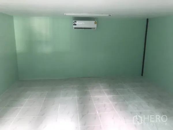 Warehouse for rent in Nonthaburi - Air-conditioned office room inside the warehouse with tiled floor and mint green walls.
