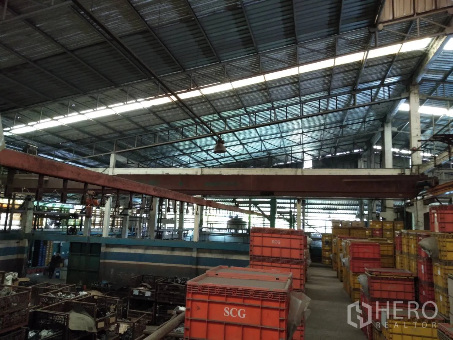 Factory for rent in Lam Luk Ka, Pathum Thani - Crane runway and hoist above bins in a large manufacturing hall.