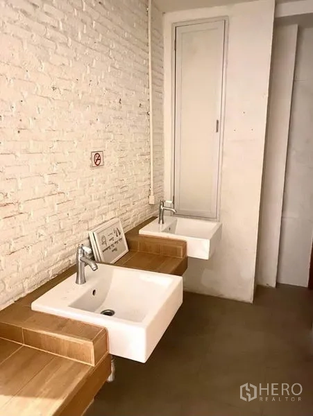 Shophouse for rent in Phaya Thai, Bangkok - Wash area featuring twin square basins on a wooden counter against a white brick wall.