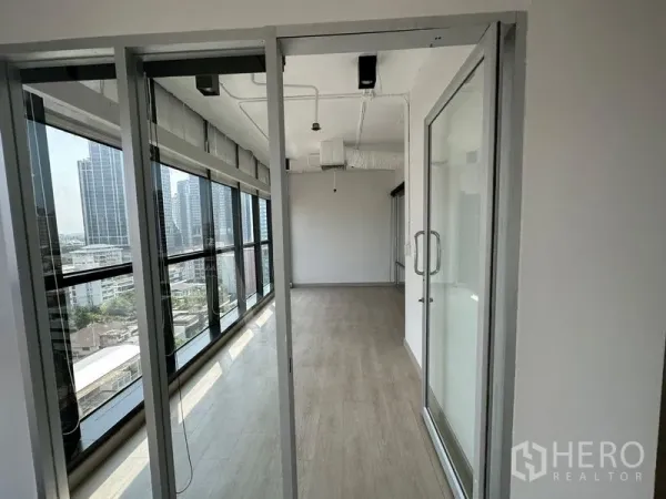 Office Space for rent - Slim glass‑partitioned meeting room with long window wall and skyline outlook.