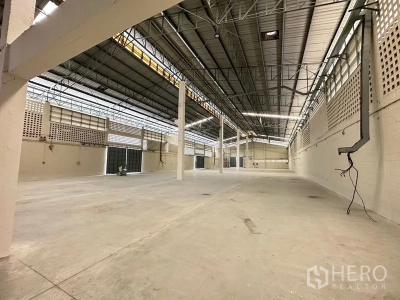 Factory for rent in Lam Luk Ka, Pathum Thani - Long clear-span warehouse space with ventilation block walls and multiple access doors.