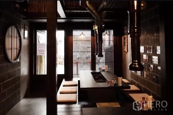 Shophouse for rent in Bang Rak, Bangkok - Restaurant-style dining area with sunken seating and wood slat windows in the shophouse.