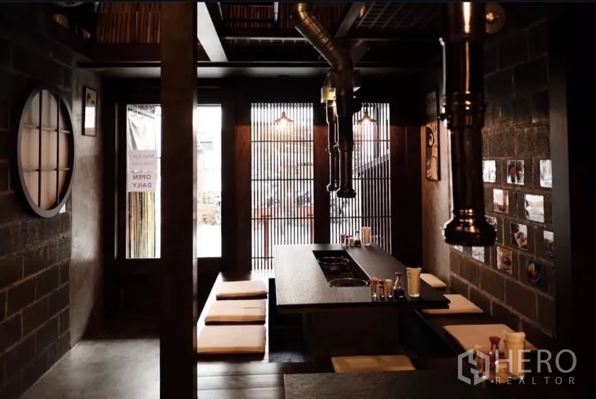Shophouse for rent in Bang Rak, Bangkok - Restaurant-style dining area with sunken seating and wood slat windows in the shophouse.
