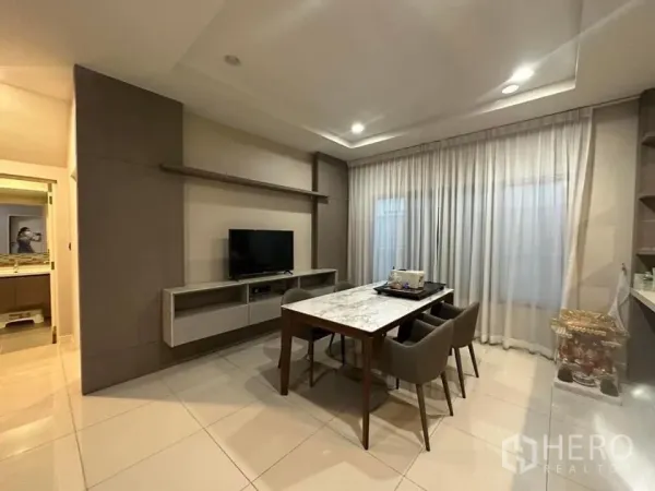 Detached House for rent in Bang Kapi, Bangkok - Dining area with a marble-top table for six and built-in media cabinet.