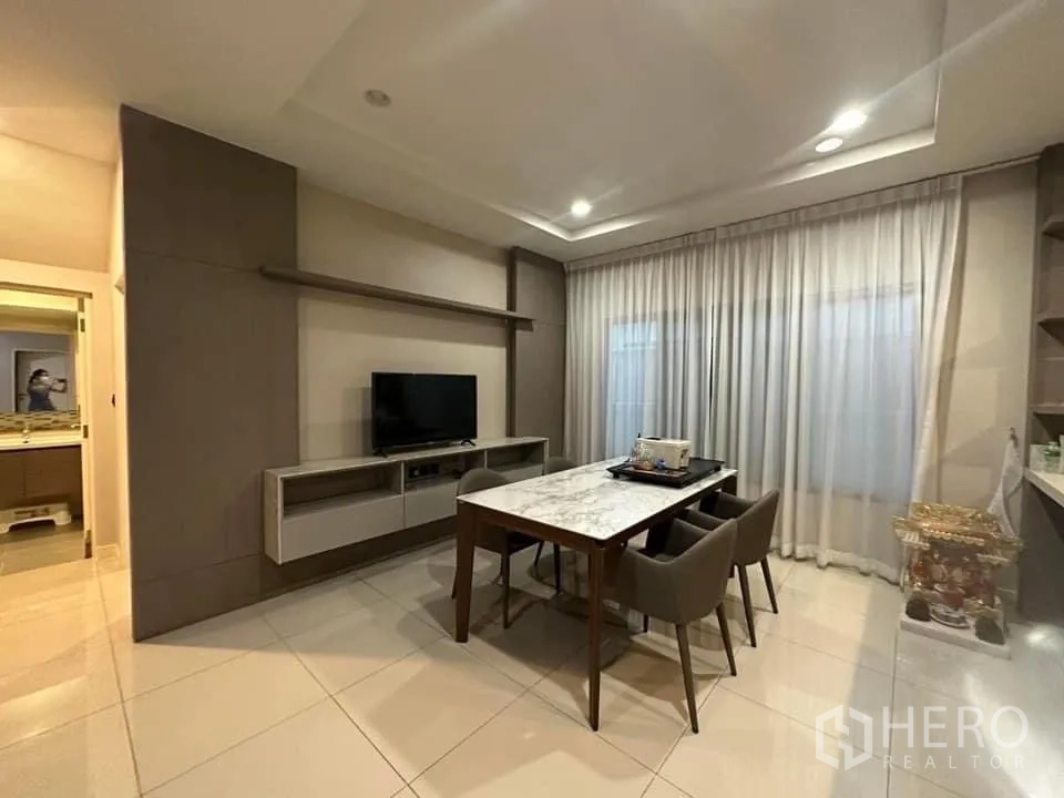 Detached House for rent in Bang Kapi, Bangkok - Dining area with a marble-top table for six and built-in media cabinet.