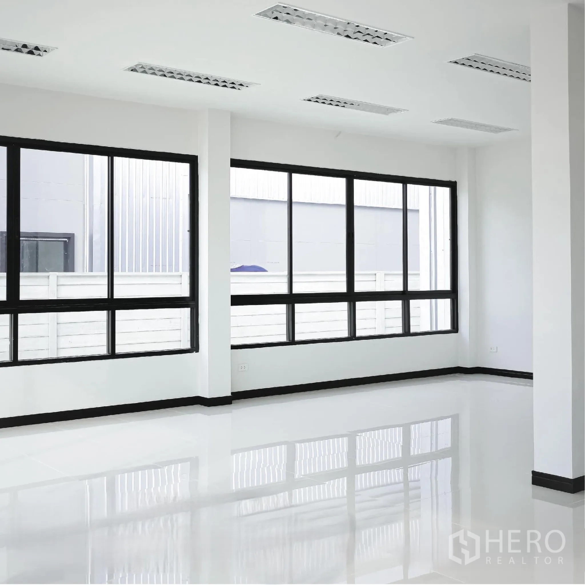 Factory for rent or sale in Bang Len, Nakhon Pathom - Bright office interior with large black-framed windows, glossy white floors, and ceiling lights.