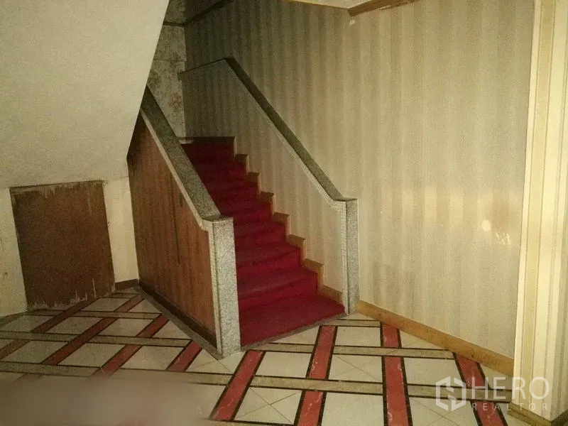 Retail Space for rent in Khlong Toei, Bangkok - Indoor staircase with red carpet and wooden handrails within the retail building.