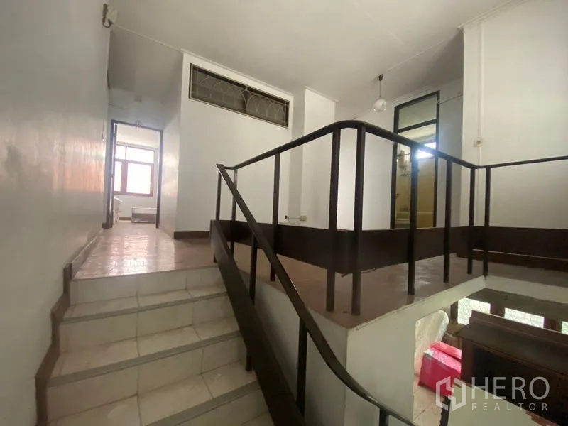Home Office for rent in Khlong Toei, Bangkok - Mid-level landing with dark handrails and split-level steps.
