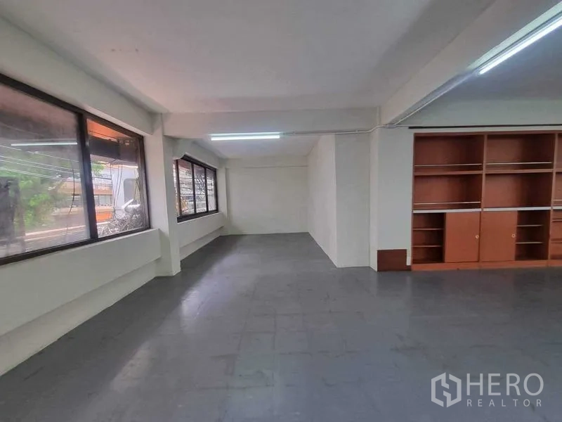Retail Space for rent in Bang Rak, Bangkok - Alternate angle of the upper-floor room showing long windows and wall-mounted storage cabinets.