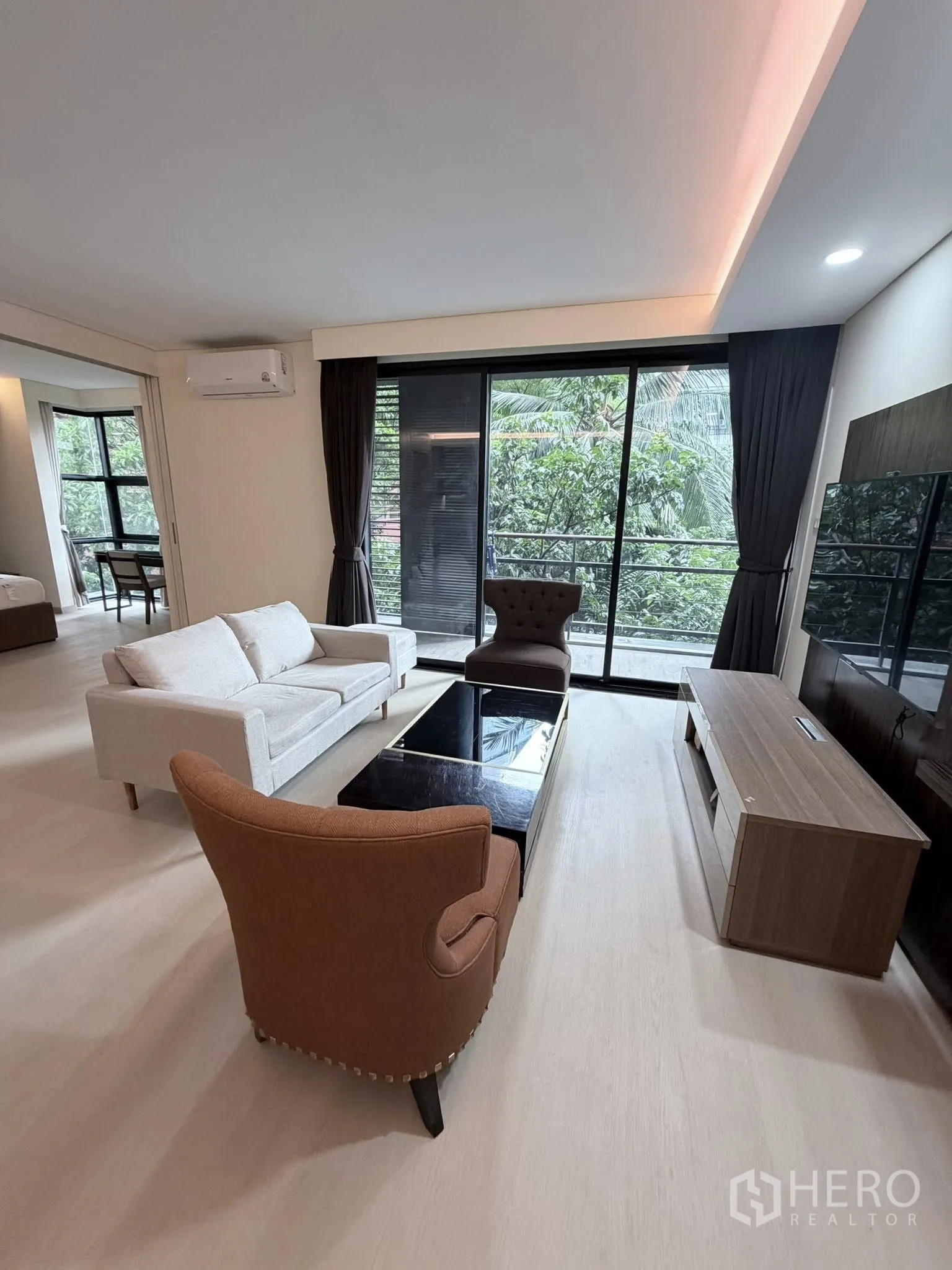 公寓 for rent in Watthana, Bangkok - 明亮客厅，沙发与单人沙发围绕茶几，外接阳台。