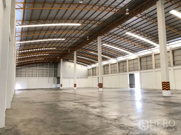 Warehouse for rent in Phra Nakhon Si Ayutthaya - Spacious clear-span warehouse interior with high steel roof and polished concrete floor.