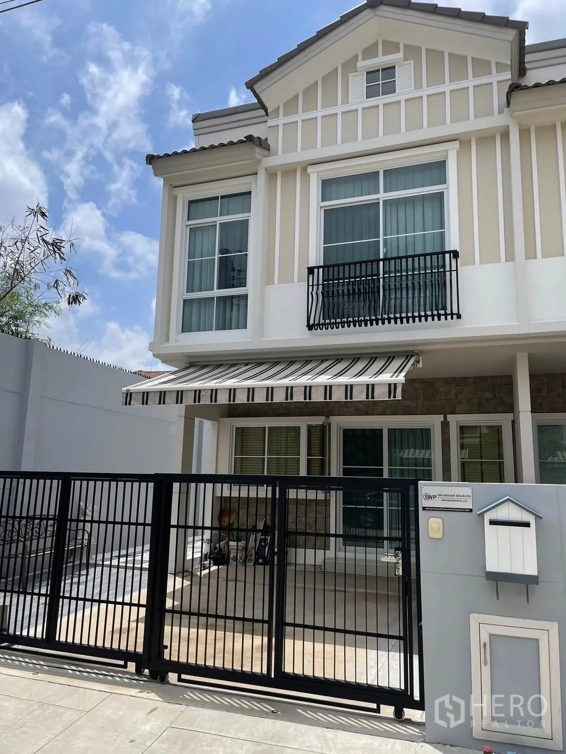 Townhouse for rent in Bang Phli, Samut Prakan - Two-storey townhouse facade with striped awning and gated carport.