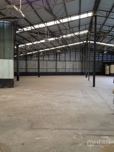 Warehouse for rent in Bang Khen, Bangkok - Spacious warehouse interior with steel truss roof, skylights and open concrete floor.