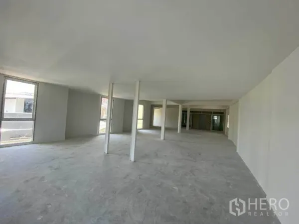 Retail Space for rent in Khlong Toei, Bangkok - Large raw commercial space with windows and central columns for a flexible layout.
