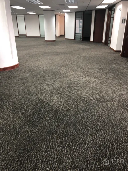 办公空间 出租在Khlong Toei, Bangkok - 宽敞办公室内景，地毯砖、圆柱与走廊两侧玻璃隔间。