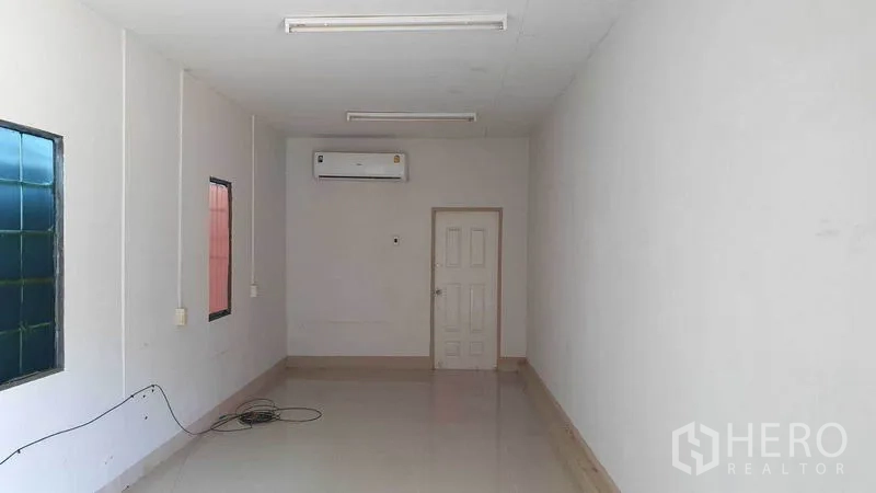 Warehouse for rent in Pathum Thani - Air-conditioned office room with tiled floor and white walls inside the warehouse.