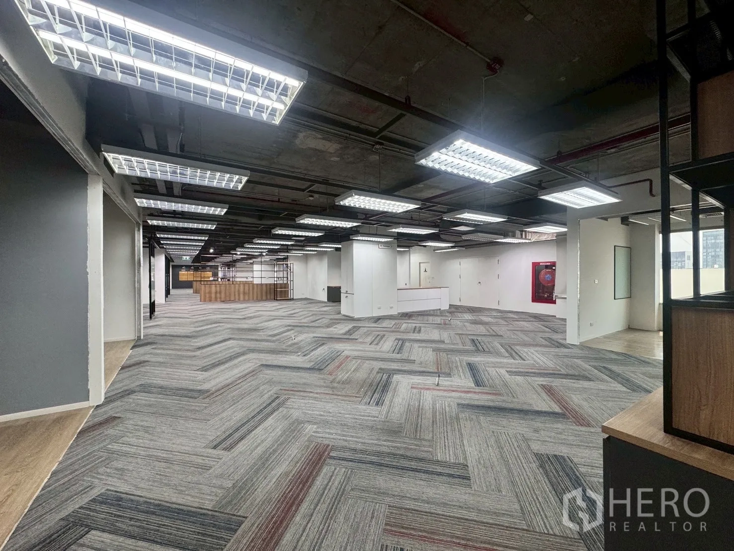 Office Space for rent in Watthana, Bangkok - Wide open floor plate with bright fluorescent lighting and a white reception area in the distance.
