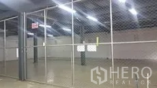 Factory for sale in Lam Luk Ka, Pathum Thani - Fenced indoor storage zone under bright industrial lighting within the factory.
