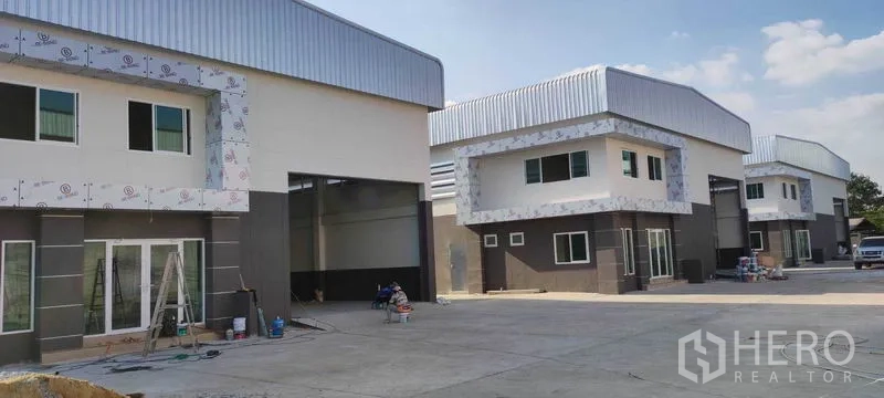 Warehouse for rent in Bang Khun Thian, Bangkok - Row of new warehouses with large roller doors and office fronts in an organized complex.