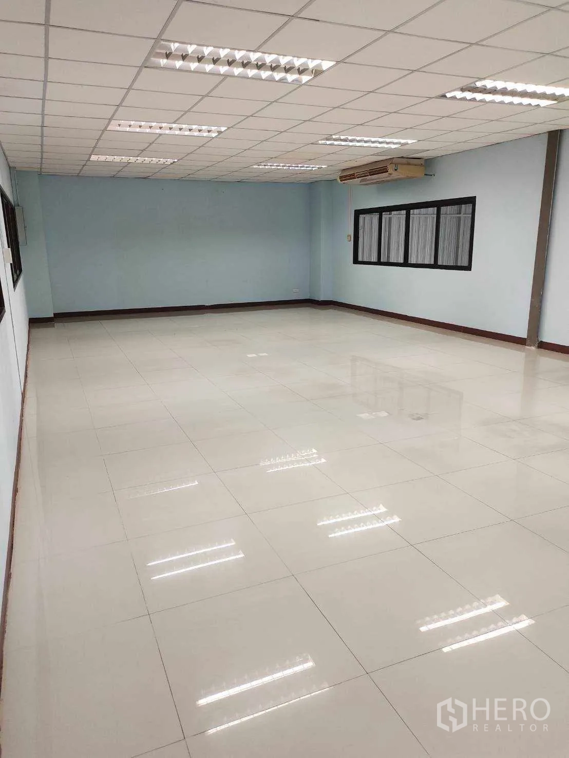 Factory for sale in Nikhom Phatthana, Rayong - Bright tiled office room with drop ceiling and fluorescent lighting.