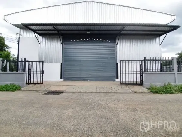 Warehouse for rent in Bang Khen, Bangkok - Symmetrical facade of the warehouse with loading bay ramp, roller door and perimeter wall.