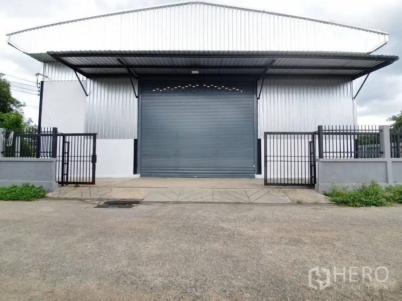 Warehouse for rent in Bang Khen, Bangkok - Symmetrical facade of the warehouse with loading bay ramp, roller door and perimeter wall.