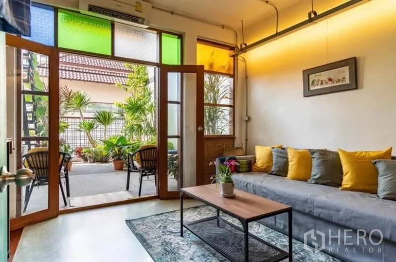 联排别墅 出租在Pathum Wan, Bangkok - 舒适起居区，连接屋顶式露台与热带植物