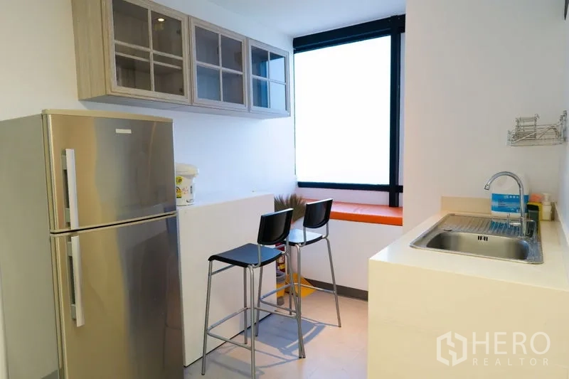 Office Space for rent - Compact staff pantry with sink, upper cabinets, bar counter and refrigerator.