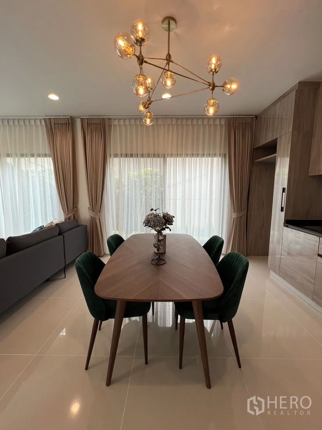 Detached House for rent in Bang Kapi, Bangkok - Dining area with wood table, velvet chairs and a statement chandelier.